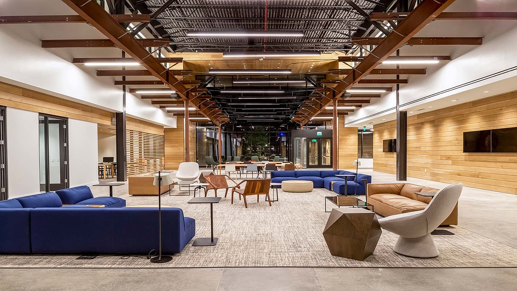 A room with a couch and chairs.