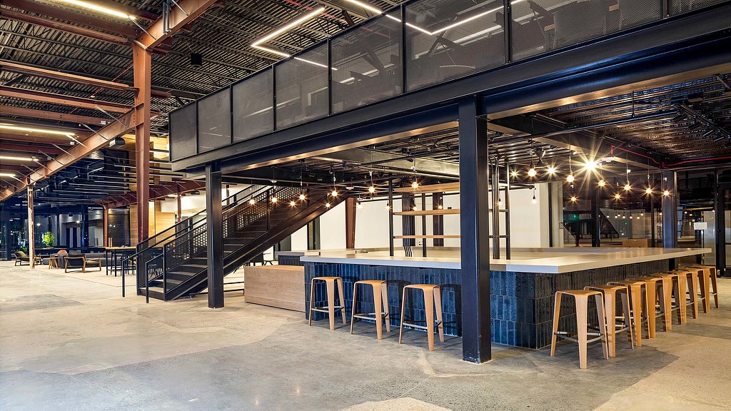 A large room with a few stools and a staircase.
