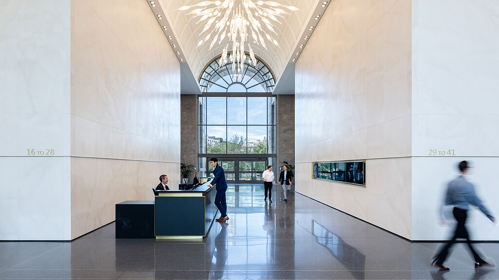 A group of people in a large room with a large window.