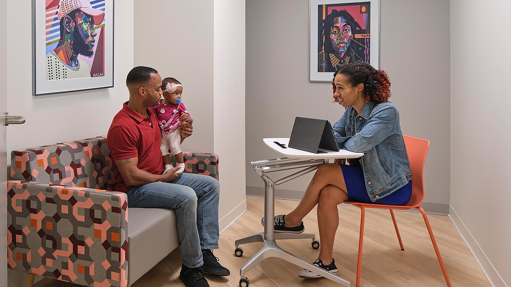 Father and baby daughter speaking with Community of Hope staff member.