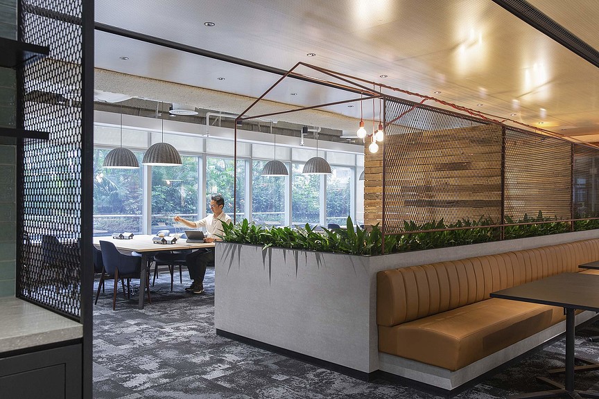 Man working on tablet in workplace cafe.