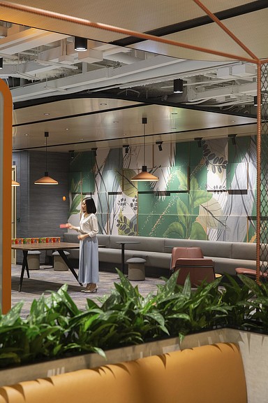 Woman playing ping pong in Standard Chartered Bank amenity space.