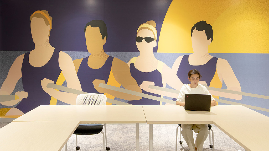 A group of people sitting at a table with a laptop.