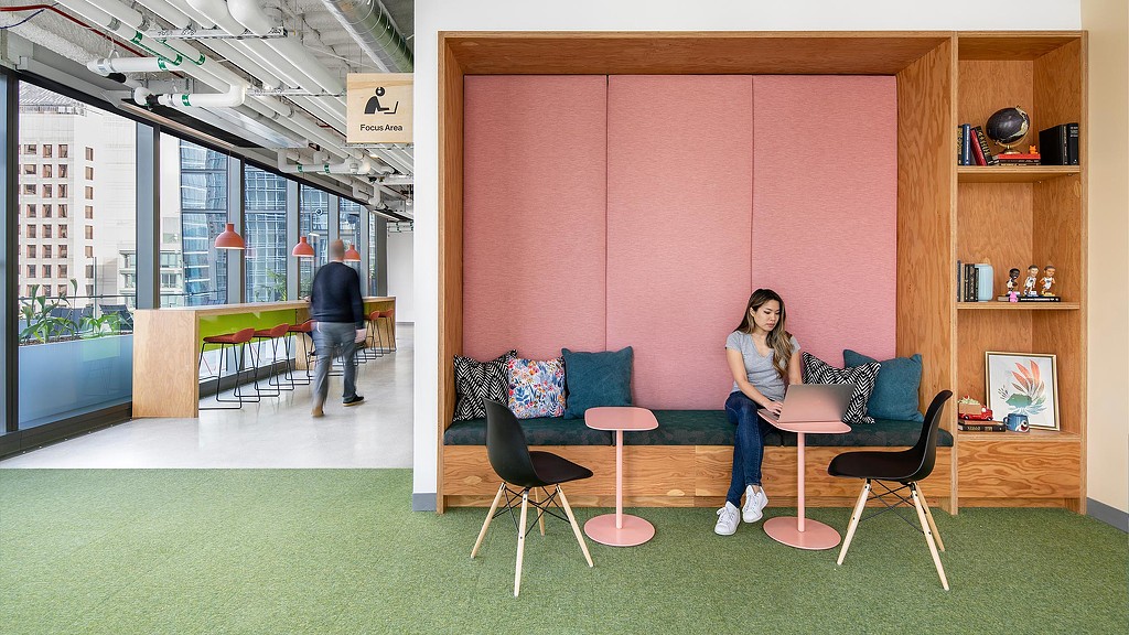 A woman on her laptop in Meta Park Tower pink nook.