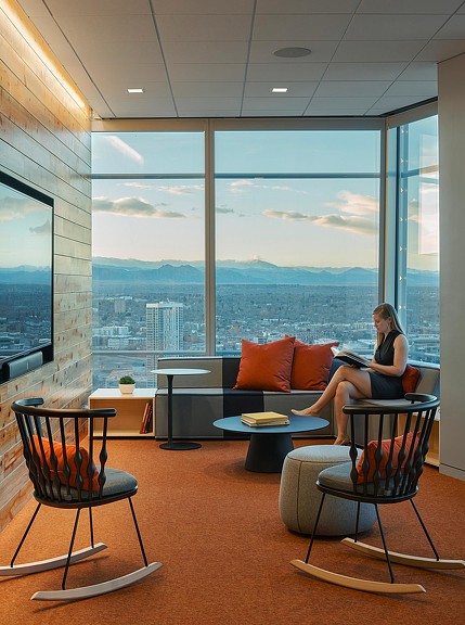 A person sitting on a couch with a laptop.