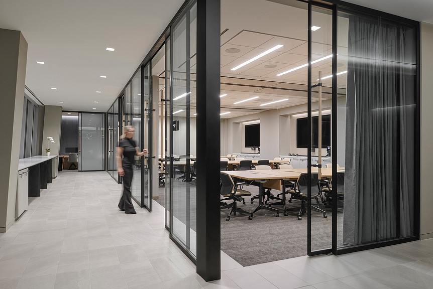 A person standing in a room with a table and chairs.
