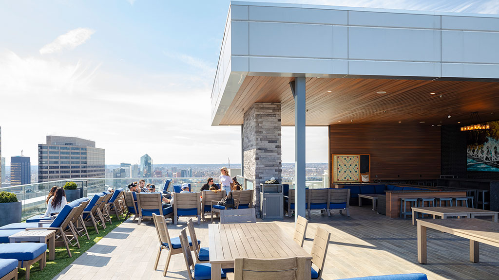 A group of people sitting at tables outside a building.