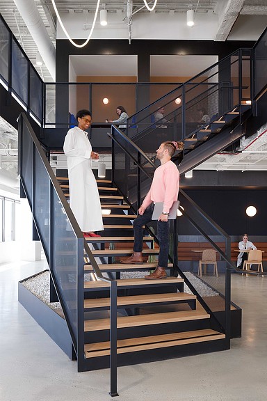 Woman and man conversing on Fivetran headquarters central staircase.