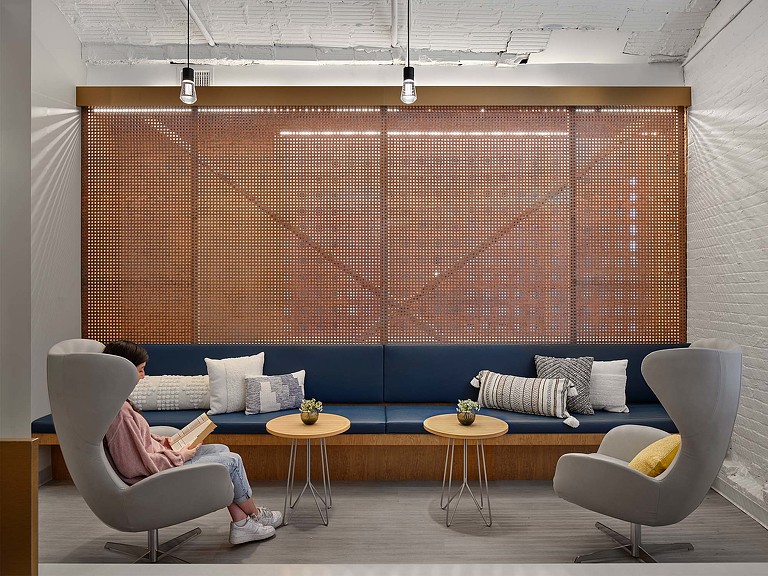A woman sitting reading in Shady Grove Fertility seating area.