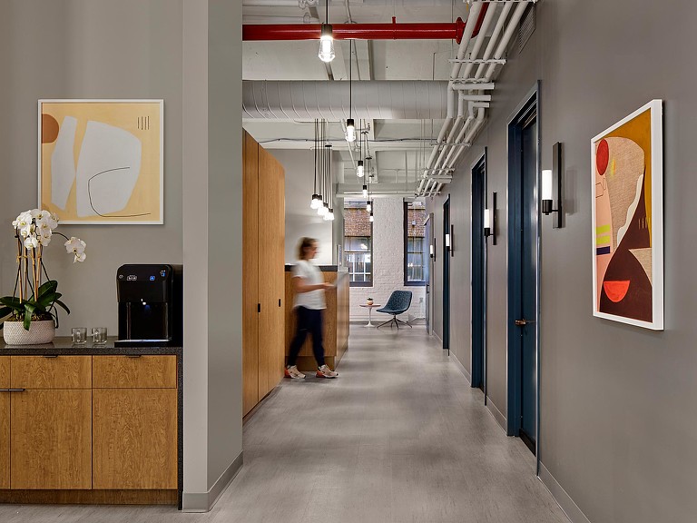 A woman walking across Shady Grove Fertility hallway.