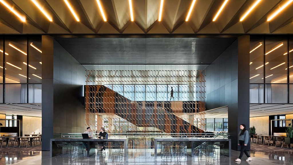 Open seating with interconnecting staircase in the background in the interiors of 225 Wyman