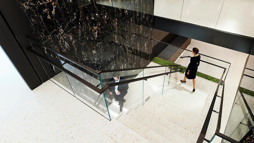 A man and woman walking down central office staircase