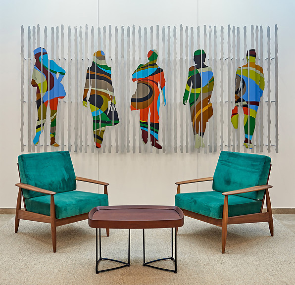 2 green lounge chairs and coffee table in front of a colorful artwork