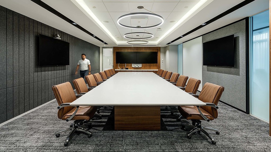 A person standing in a room with a table and chairs.