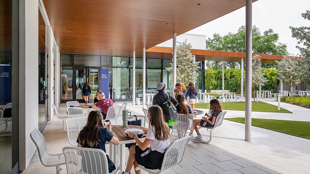 A group of people sitting at a table outside.
