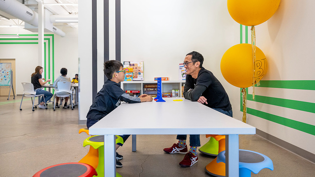 A couple of men playing ping pong.