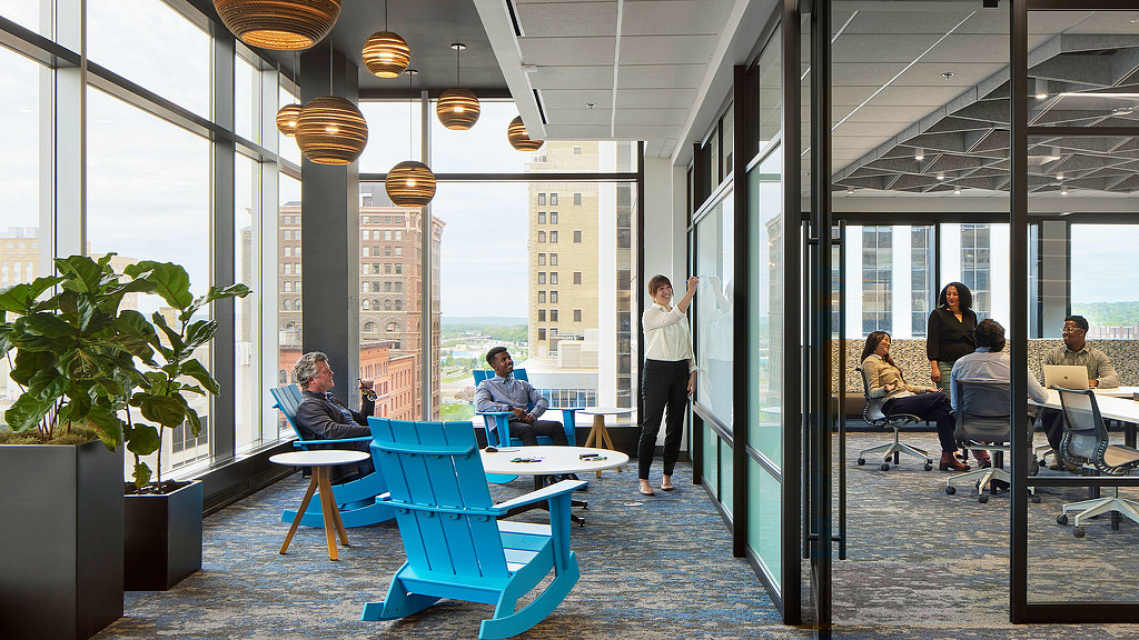 An interior office with floor to ceiling windows and separated conference areas