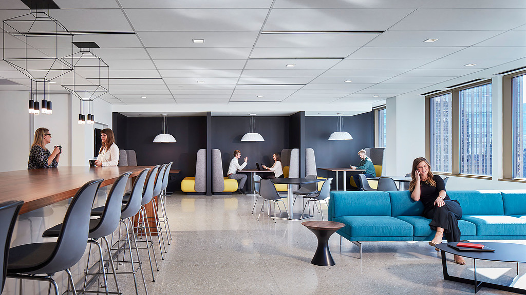 A group of people sitting in a room with tables and chairs.
