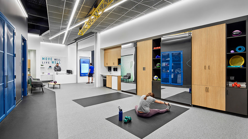 A person lying on the floor in a room with a person standing.