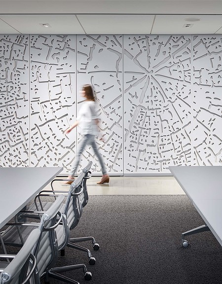 Woman waling through financial tech firm hall with wall art installation
