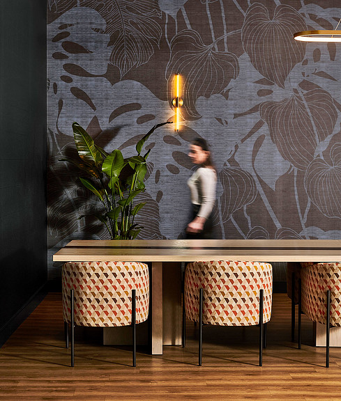 A person standing in front of a wall with a textured wallpaper at Voco Holiday Inn