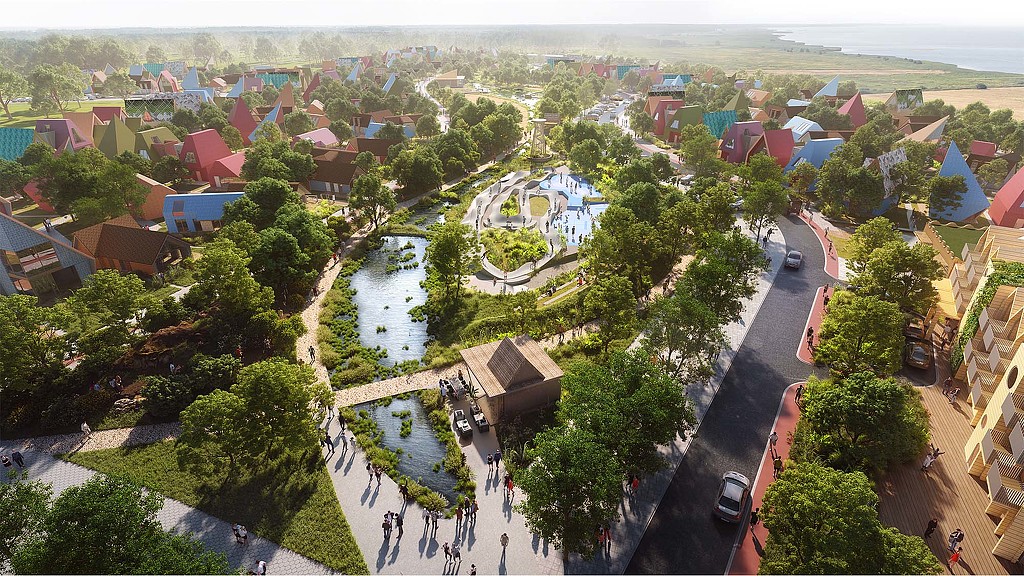 A park with a pond and buildings.