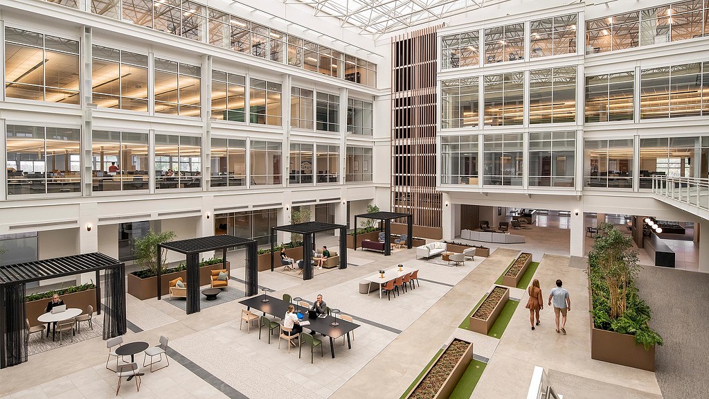 A large building with many windows and people walking around.