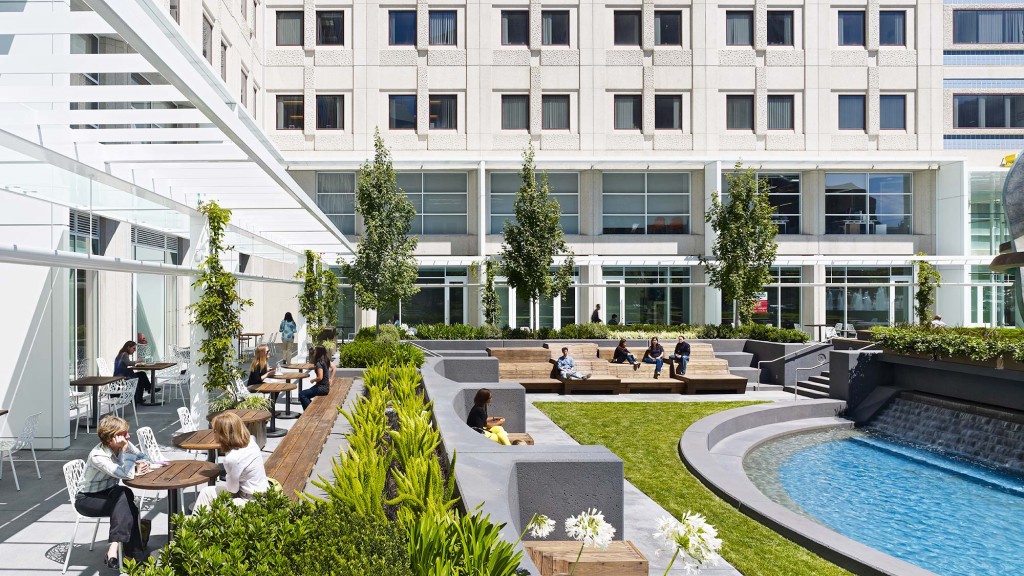 A building with a pool and people sitting around it.