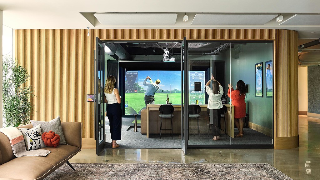 A group of people looking at a large screen.