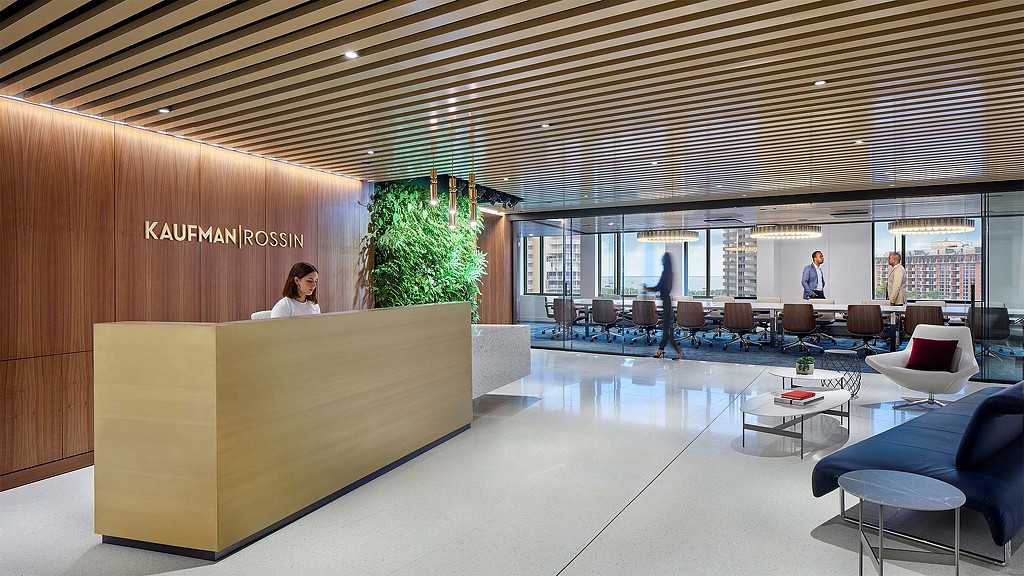 A room with a large table and chairs and a large screen.