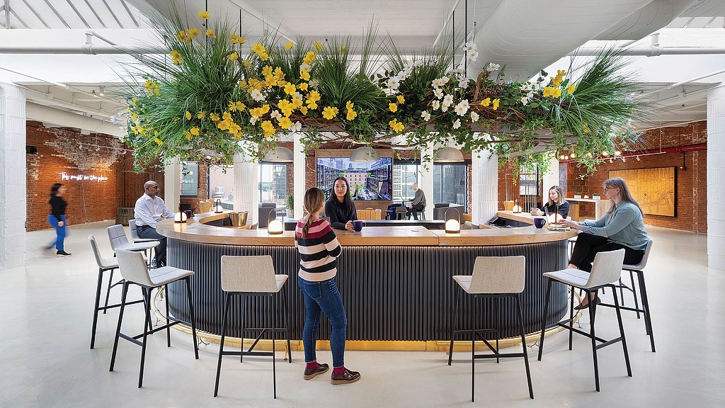 A group of people sitting at a table with flowers on it.