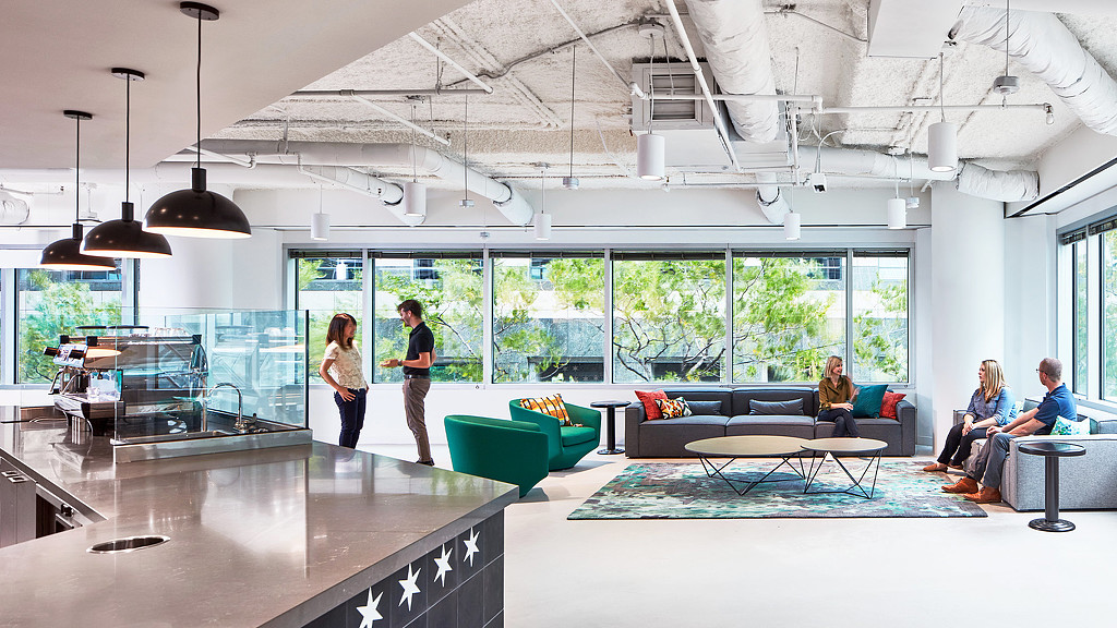A group of people in a room with large windows and a cafe