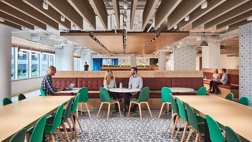 People sitting at a long table in a modern cafe space