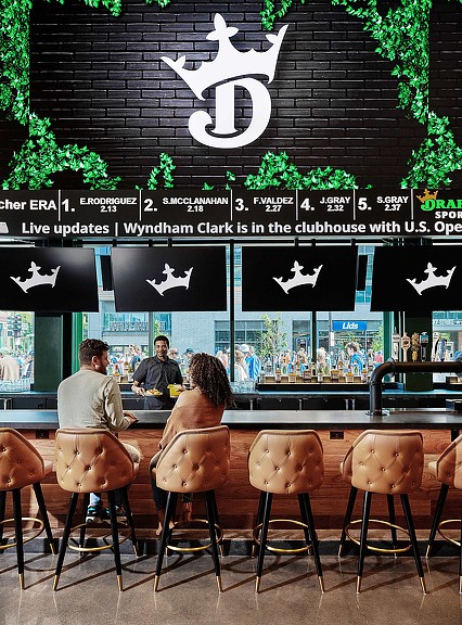 A bar with warm leather stools and screens