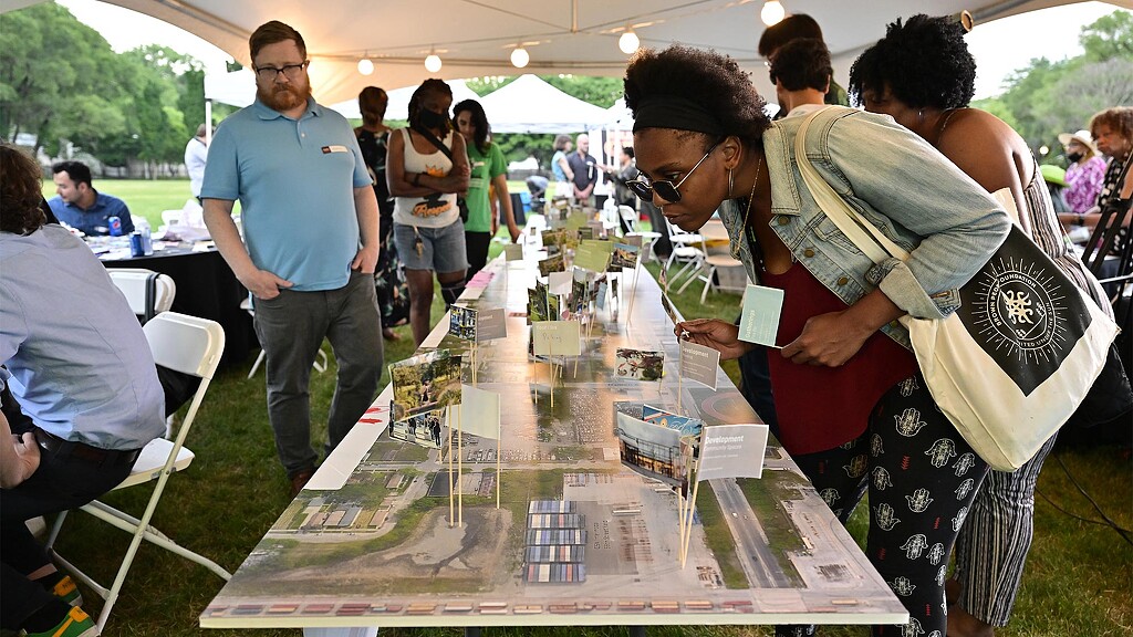 A group of people standing at a table at the visioning session for the Englewood Line Redevelopment Plan
