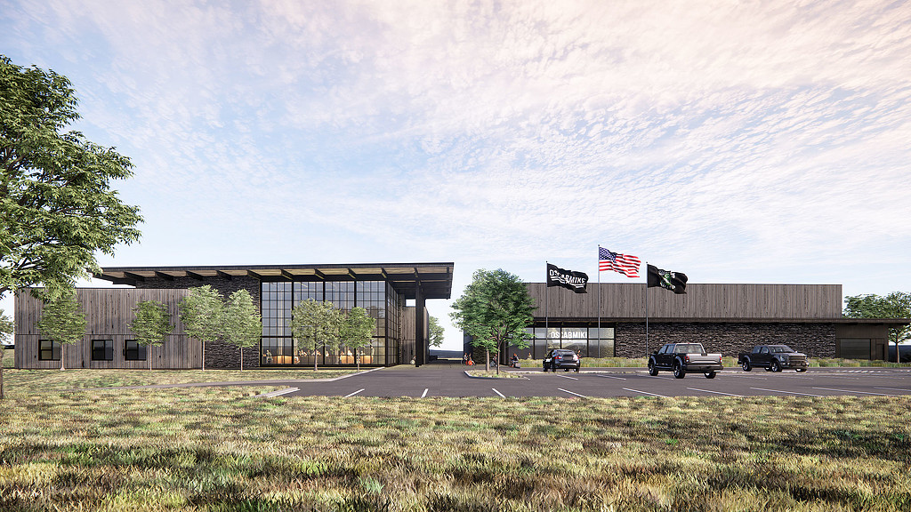 A view of a building straight on with flags and a slanted roof