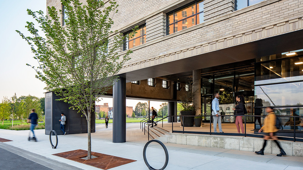 People walking outside of the book depository with bike racks and stairs