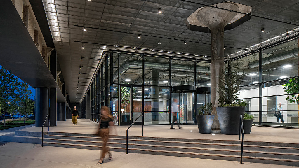 People departing the book depository at night with large glass windows