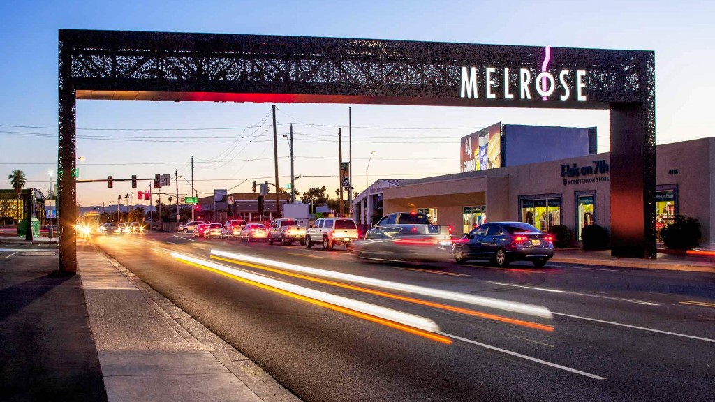 A street with cars and a sign over it.