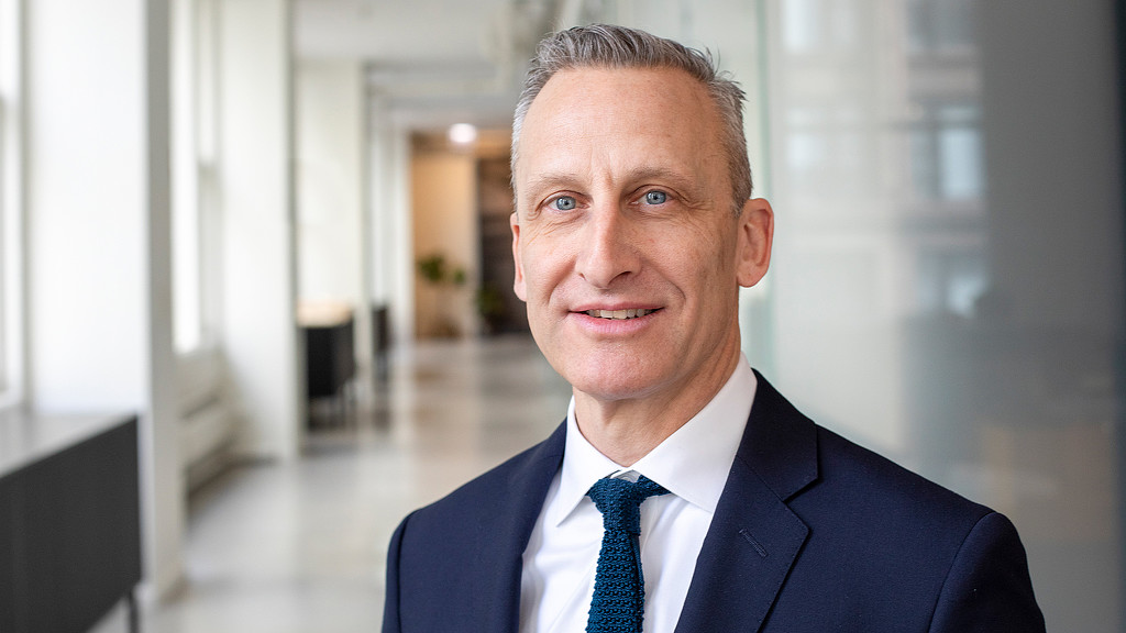 Stephen Katz from Gensler Chicago in a long bright hallway