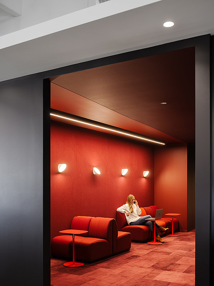 A person sitting on a red couch.