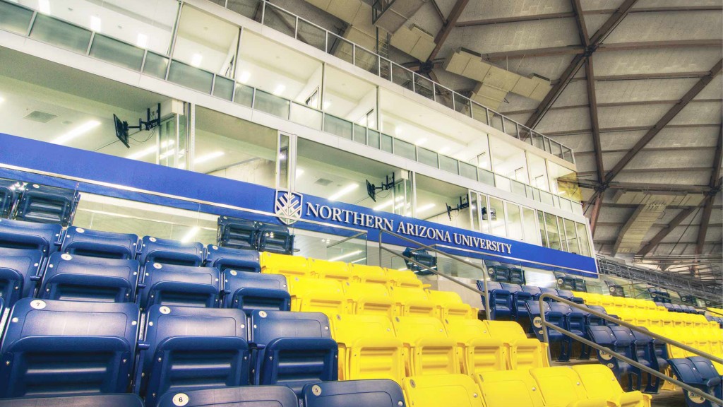 A large room with rows of blue chairs and a blue wall.