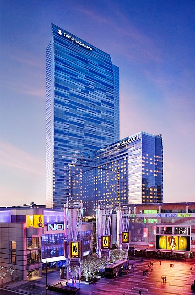 A couple of tall buildings with lights on at night.