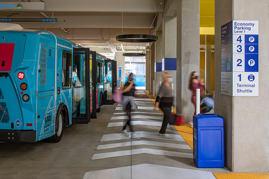 People getting off blue shuttles at LAX Economy Parking Garage