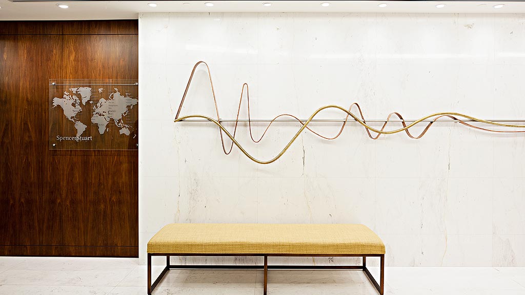 A bench in front of a wall.