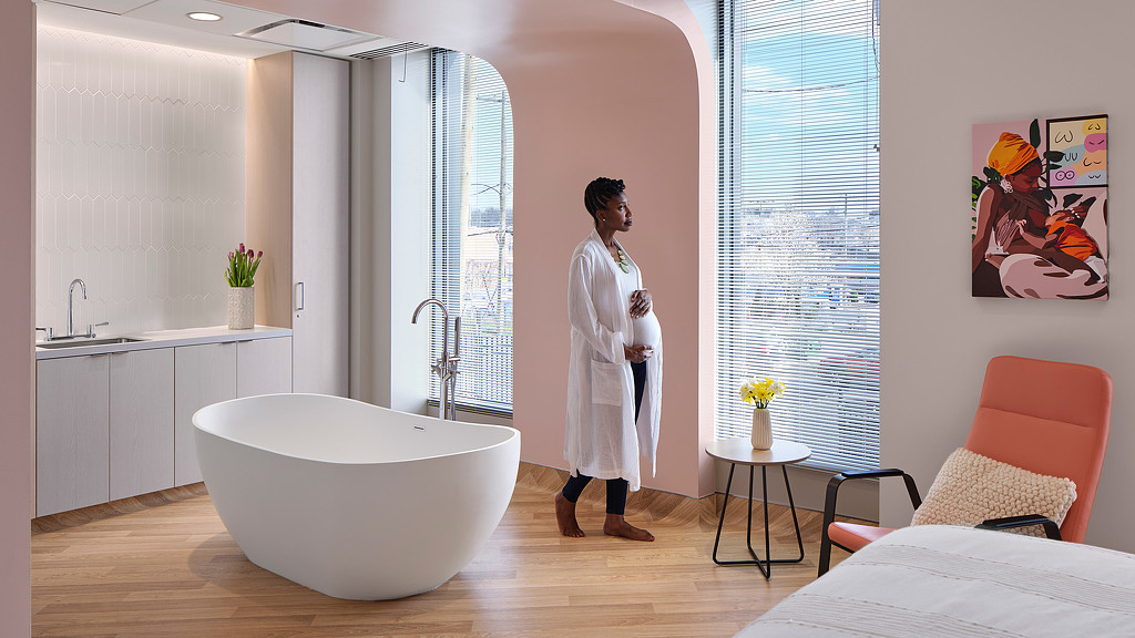 A person in a white coat in a bathroom.