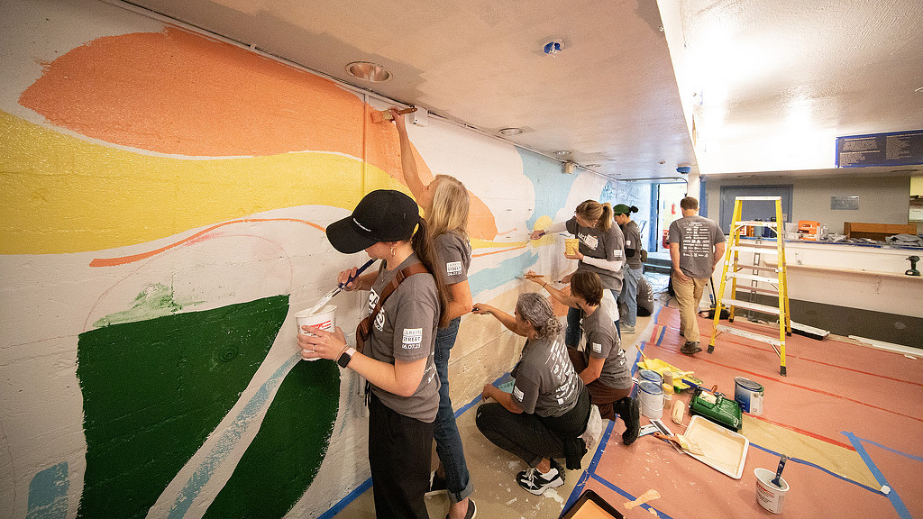 Volunteers painting mural at The Lark Inn
