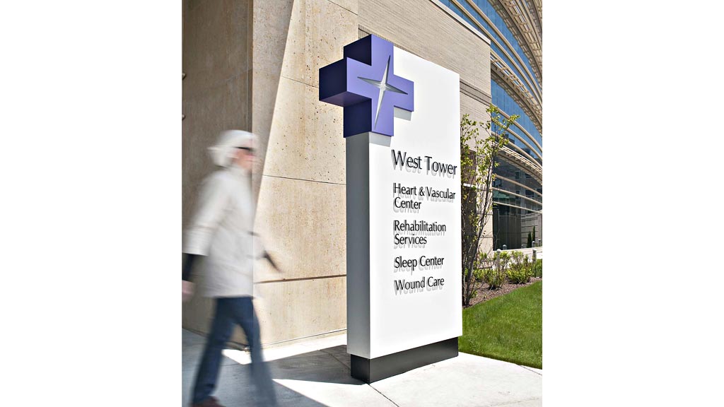 A person walking by a sign.