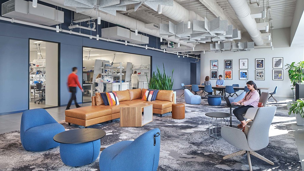 A group of people sitting in chairs in a room with a couch and a table.