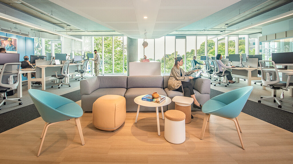 A person sitting in a chair in a room with other people.